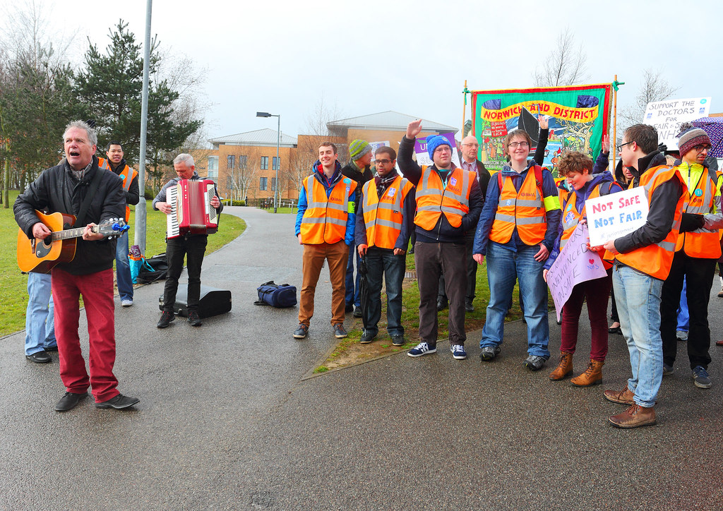 Junior Doctors being entertained by The Red Flag in front of Norwich Trades Council banner A3